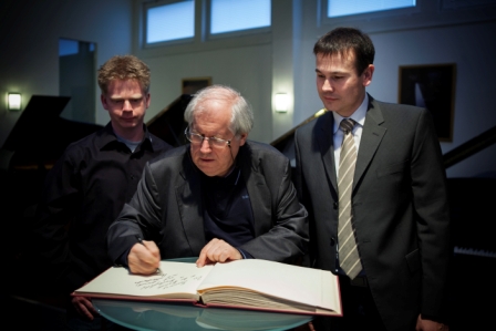 Grigory Sokolov unterschreibt im Gästebuch Gästebuch des Pianohaus Micke