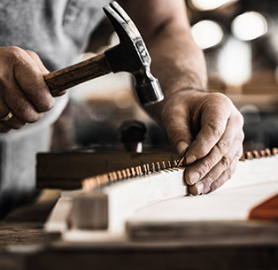 Auf alle Piano-Reparaturarbeiten gewähren wir eine Garantie von fünf Jahren. Handwerker repariert einen Steinway Flügel.